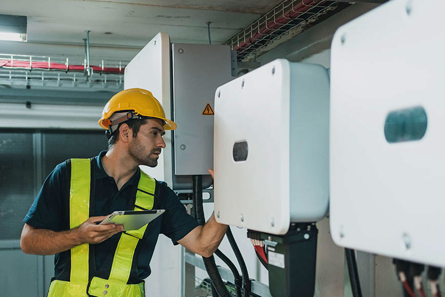 A maintenance worker works on electrical inverters