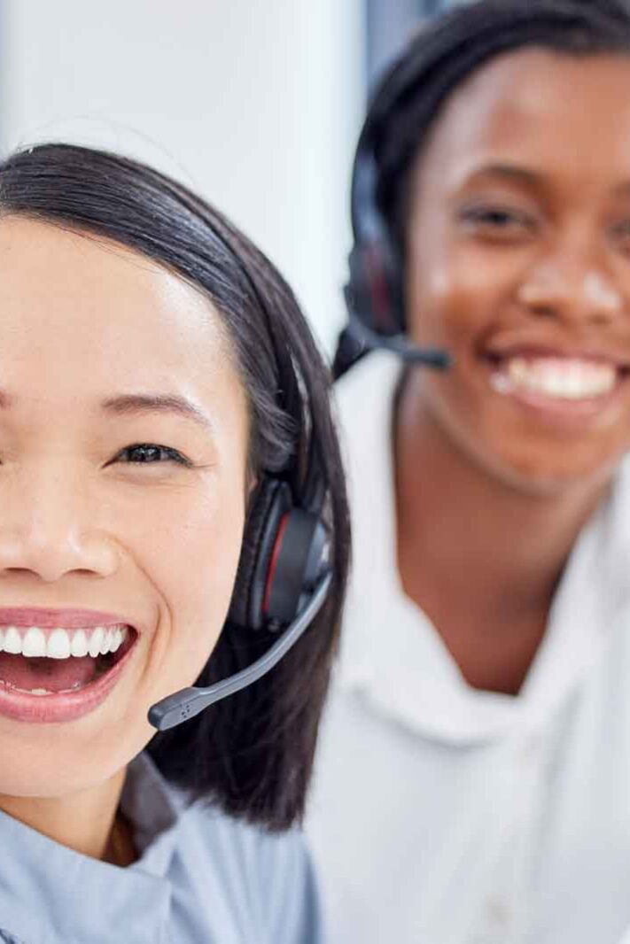Two customer service employees pose happily for a selfie